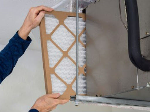 ACC technician changing furnace filter.